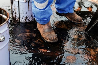 Worker Cleaning Up Oil Spill Outdoors Worker Cleaning Up Oil Spill Outdoors